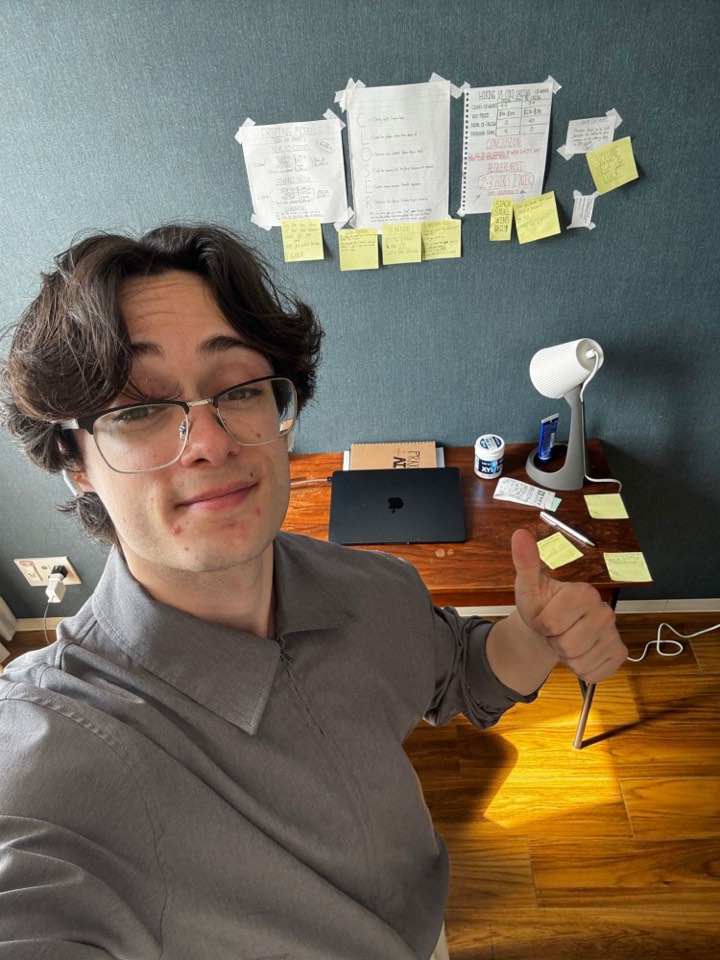 Isaac Canavan at his desk, strategy notes taped to the wall behind him
